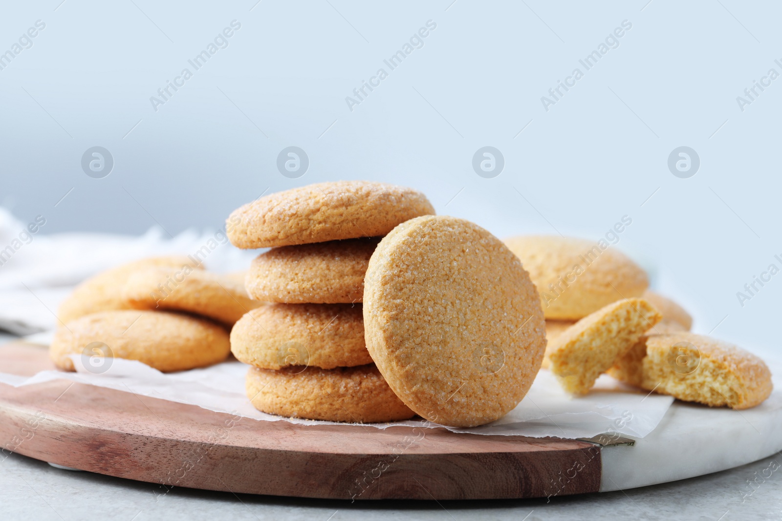 Photo of Many tasty sugar cookies on wooden board