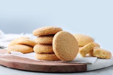 Photo of Many tasty sugar cookies on wooden board