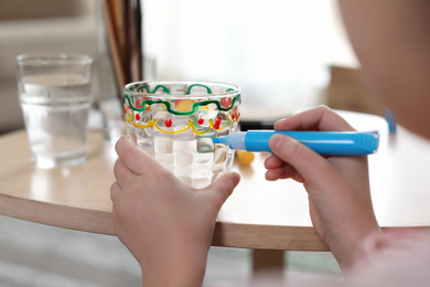 Photo of Little girl painting glass at table indoors, closeup. Creative hobby