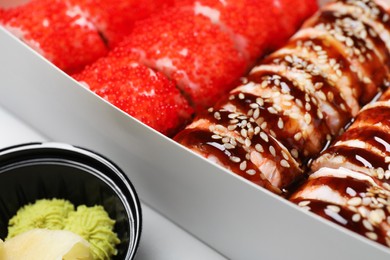 Photo of Food delivery. Delicious sushi rolls served on table, closeup