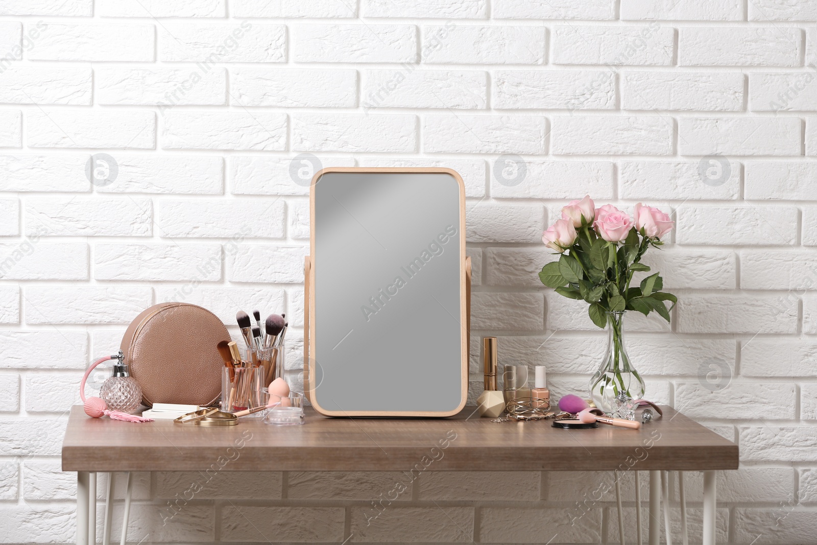 Photo of Dressing table with different makeup products and accessories in room interior