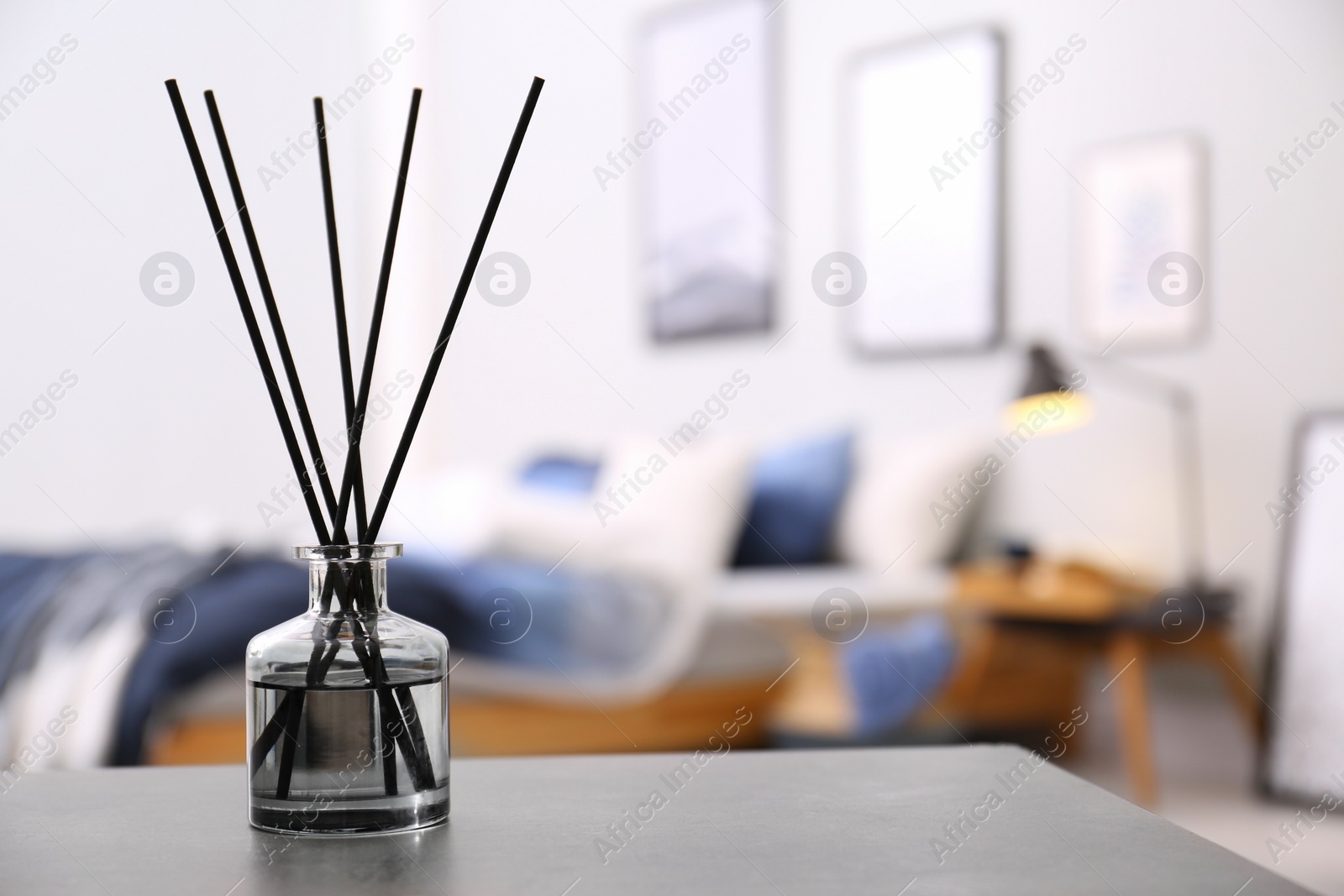 Photo of Aromatic reed air freshener on table in room. Space for text