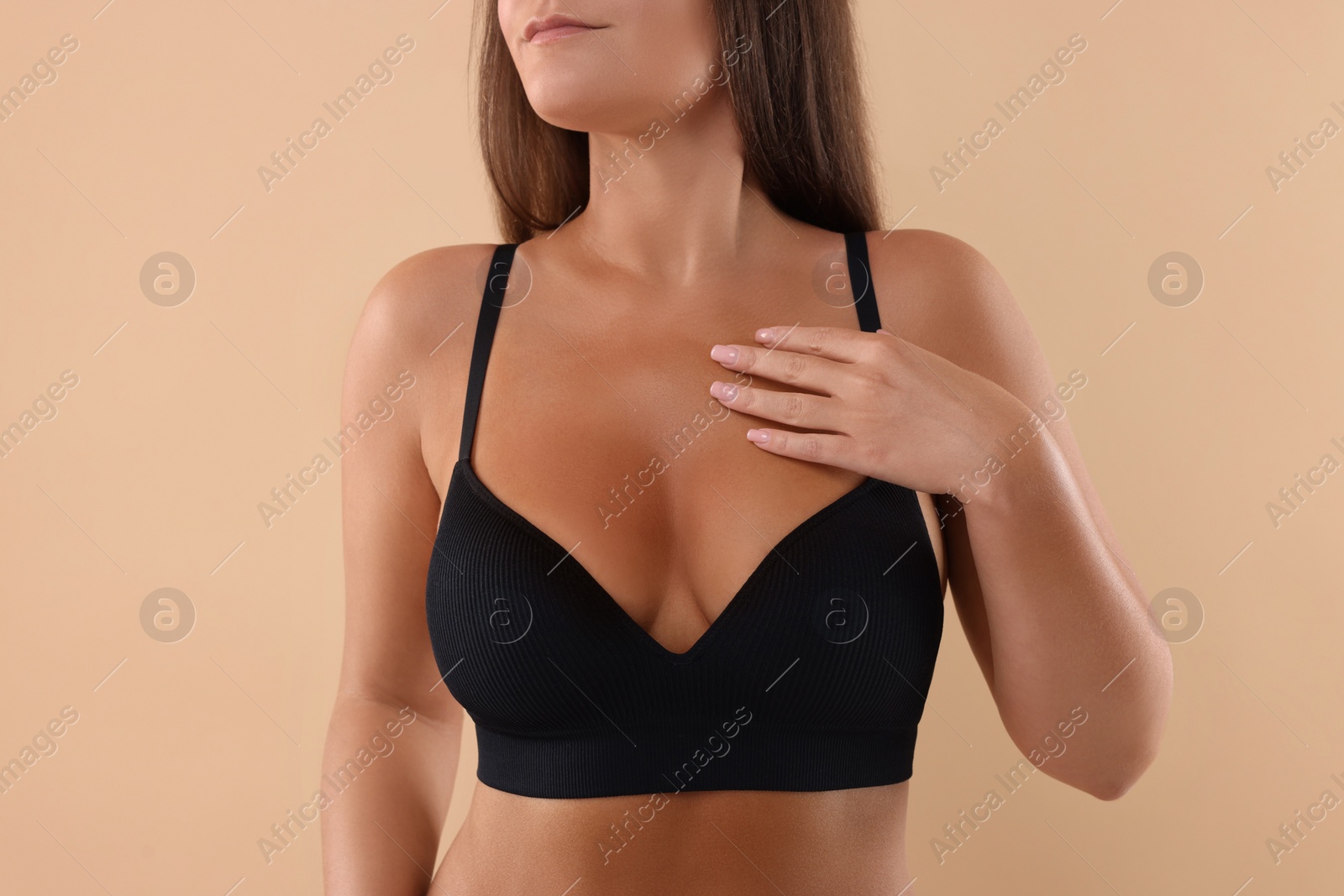 Photo of Woman with beautiful breast on beige background, closeup