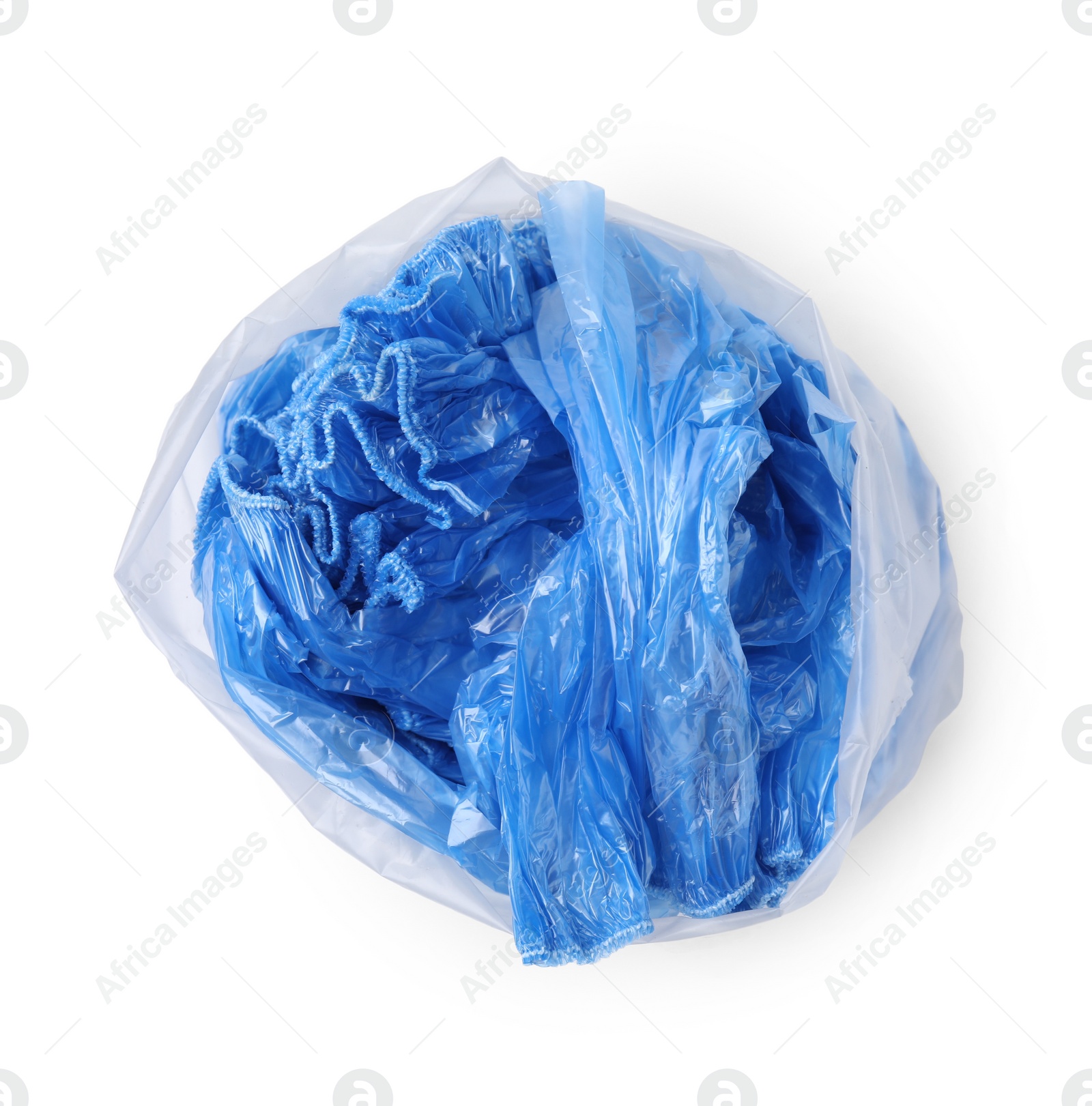 Photo of Blue medical shoe covers in package isolated on white, top view