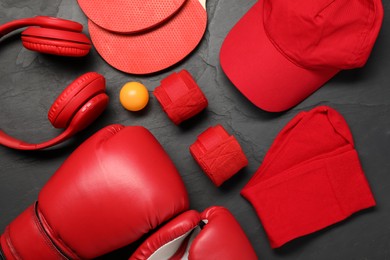 Different sports equipment on black table, flat lay