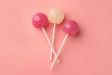 Tasty lollipops on pink background, flat lay