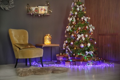 Photo of Room interior with beautiful Christmas tree and gifts