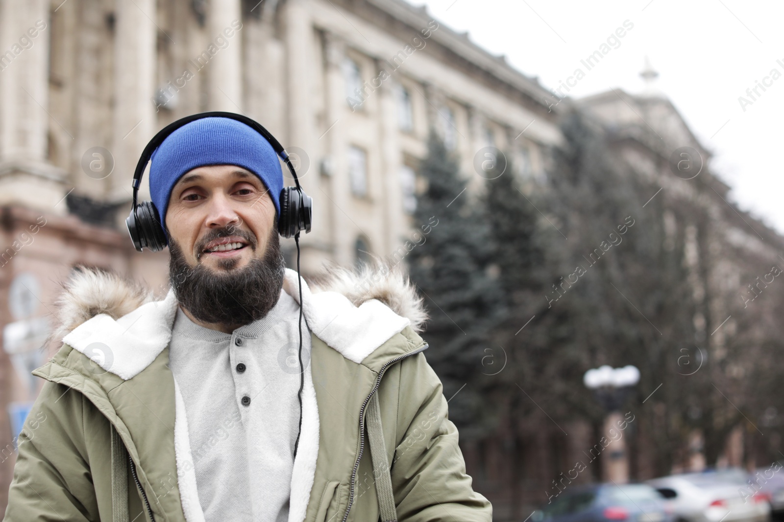 Photo of Mature man with headphones listening to music outdoors