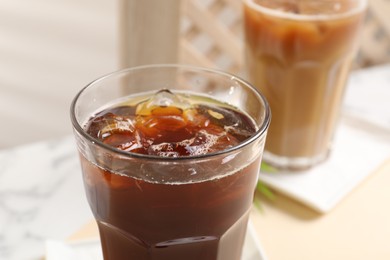 Refreshing iced coffee in glass on table, closeup