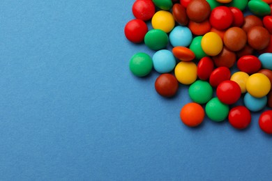 Photo of Tasty colorful candies on blue background, flat lay. Space for text