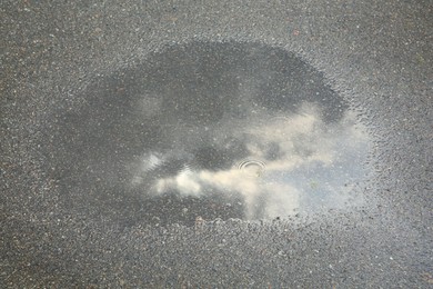 Photo of View of puddle on asphalt outdoors. Rainy day