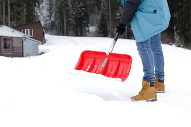 Photo of Man removing snow with shovel near house. Space for text