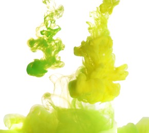 Splashes of yellow and green inks on light background, closeup