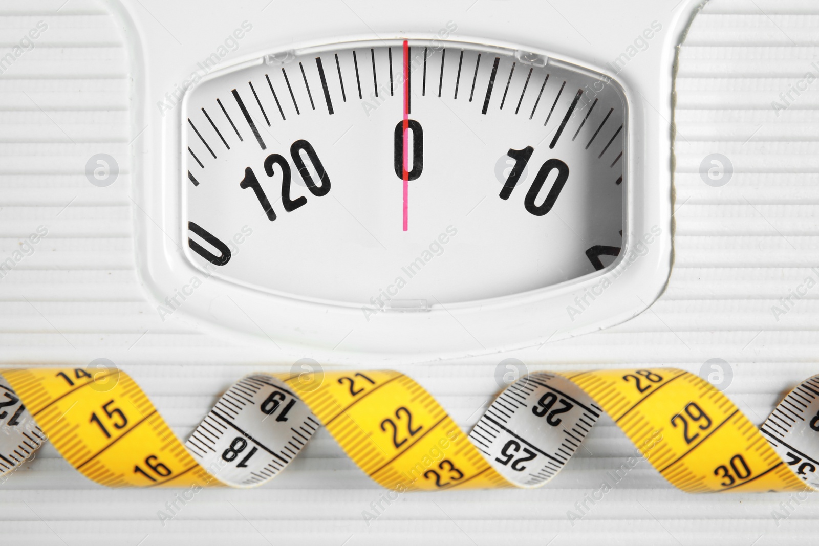 Photo of Scales with tape measure, closeup view. Diet and weight loss