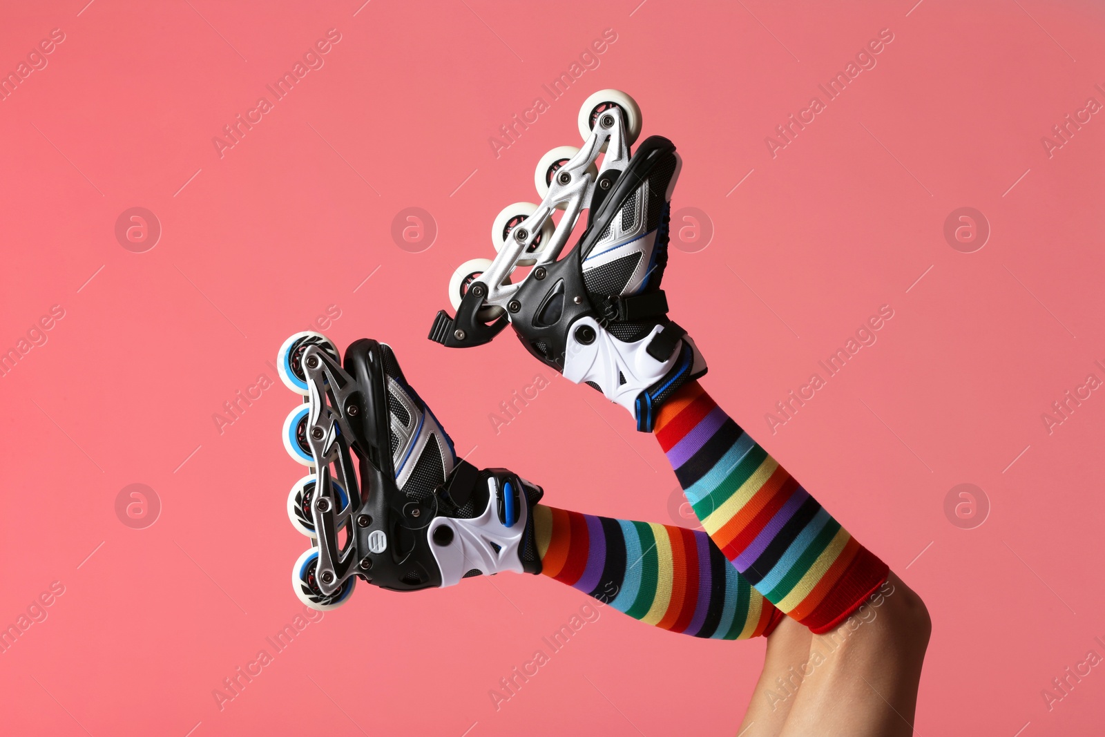 Photo of Woman with roller skates on color background, closeup