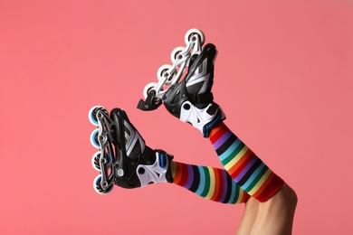 Photo of Woman with roller skates on color background, closeup