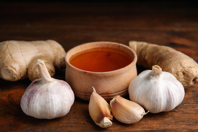 Photo of Fresh garlic and other natural cold remedies on wooden table