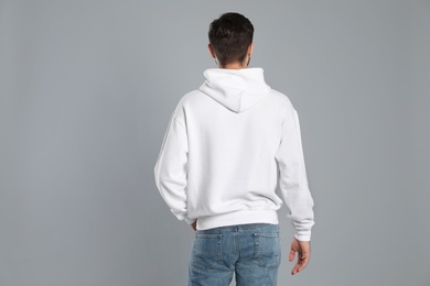 Photo of Young man in sweater on grey background. Mock up for design