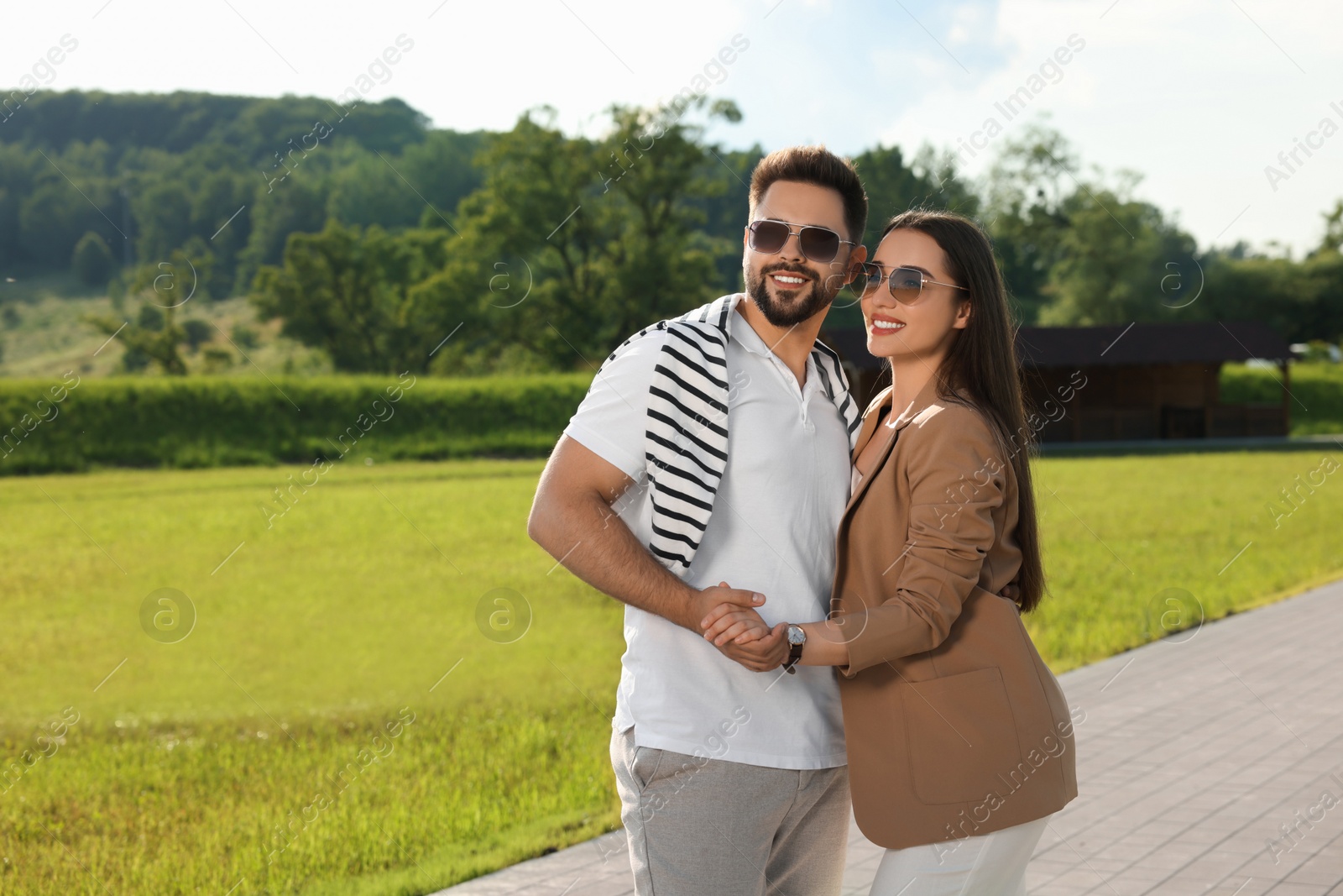 Photo of Romantic date. Beautiful couple spending time together in park, space for text