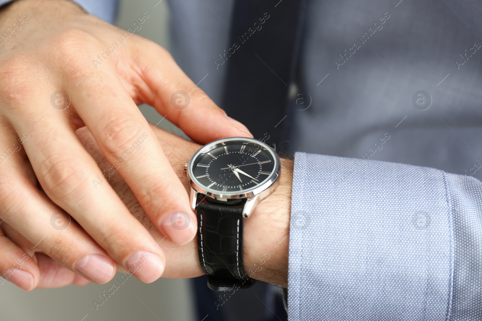 Photo of Man wearing luxury wrist watch with leather band, closeup