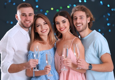 Portrait of happy friends with champagne in glasses on blurred background