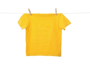 Photo of One yellow t-shirt drying on washing line isolated on white