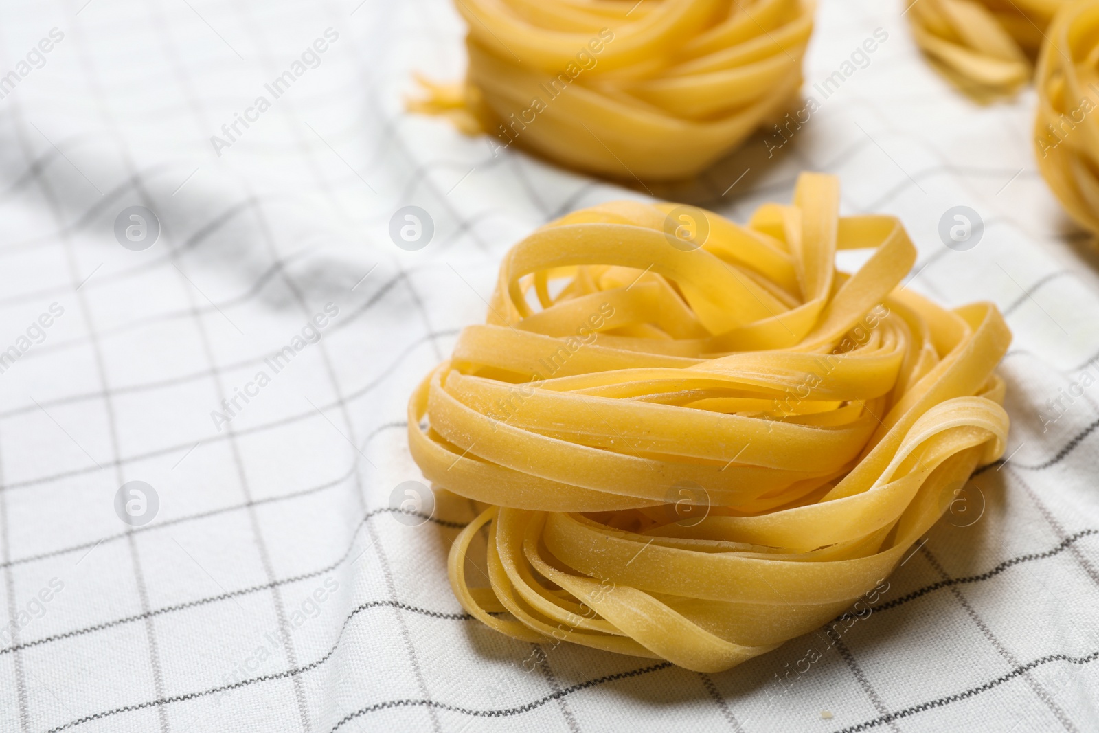 Photo of Tagliatelle pasta on white tablecloth, closeup view