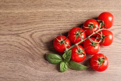 Photo of Fresh cherry tomatoes on wooden background, top view. Space for text