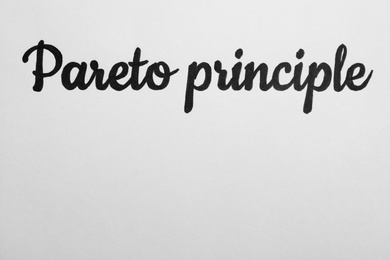 Photo of Words PARETO PRINCIPLE on white background, top view. Space for text