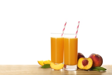 Freshly made tasty peach juice on wooden table against white background