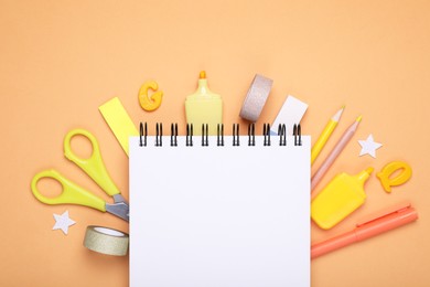Photo of Flat lay composition with notebook and other school stationery on orange background, space for text. Back to school