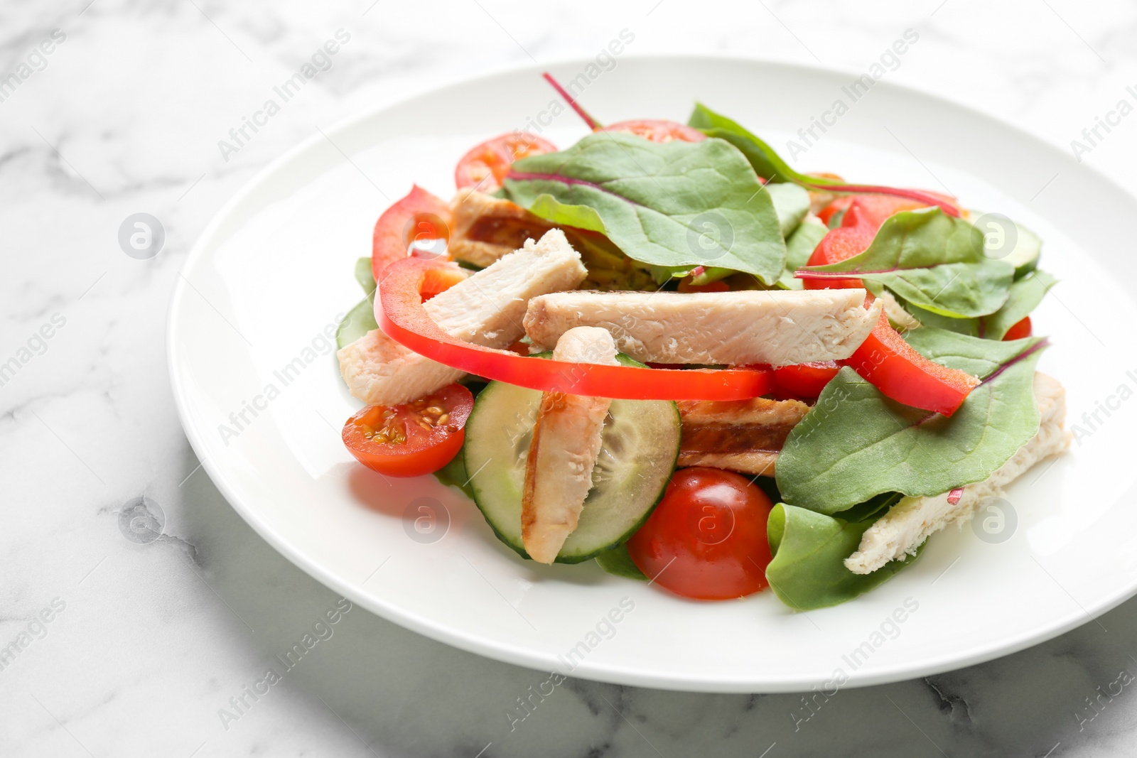 Photo of Delicious fresh chicken salad served on white marble table, closeup