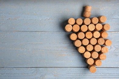 Photo of Grape made of wine bottle corks on grey wooden table, top view. Space for text