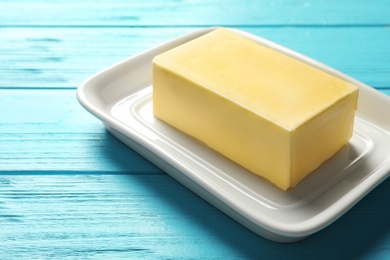 Photo of Dish with fresh butter on wooden background, closeup