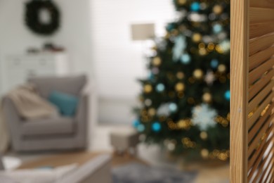 Photo of Room with Christmas tree decorated for holiday and folding screen, selective focus. Festive interior