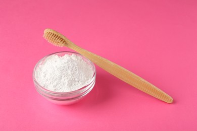 Photo of Bowl of tooth powder and brush on pink background