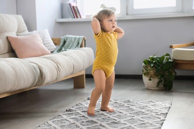 Cute baby learning to walk in living room