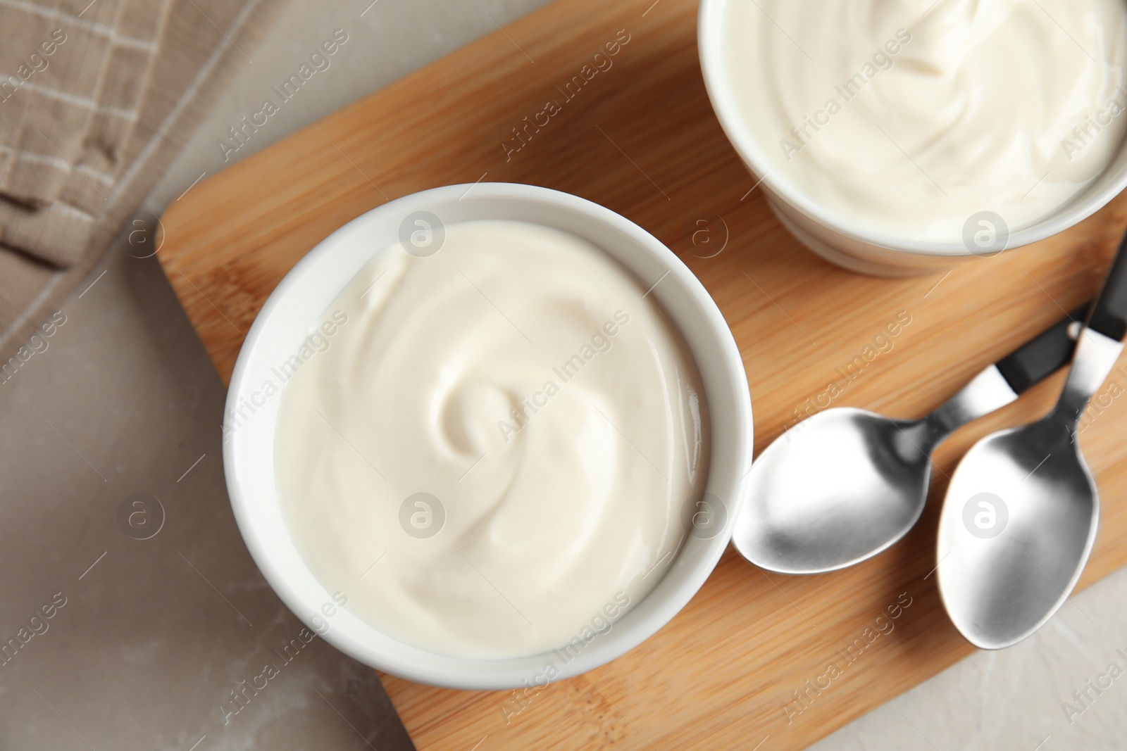 Photo of Bowls with creamy yogurt served on table, top view