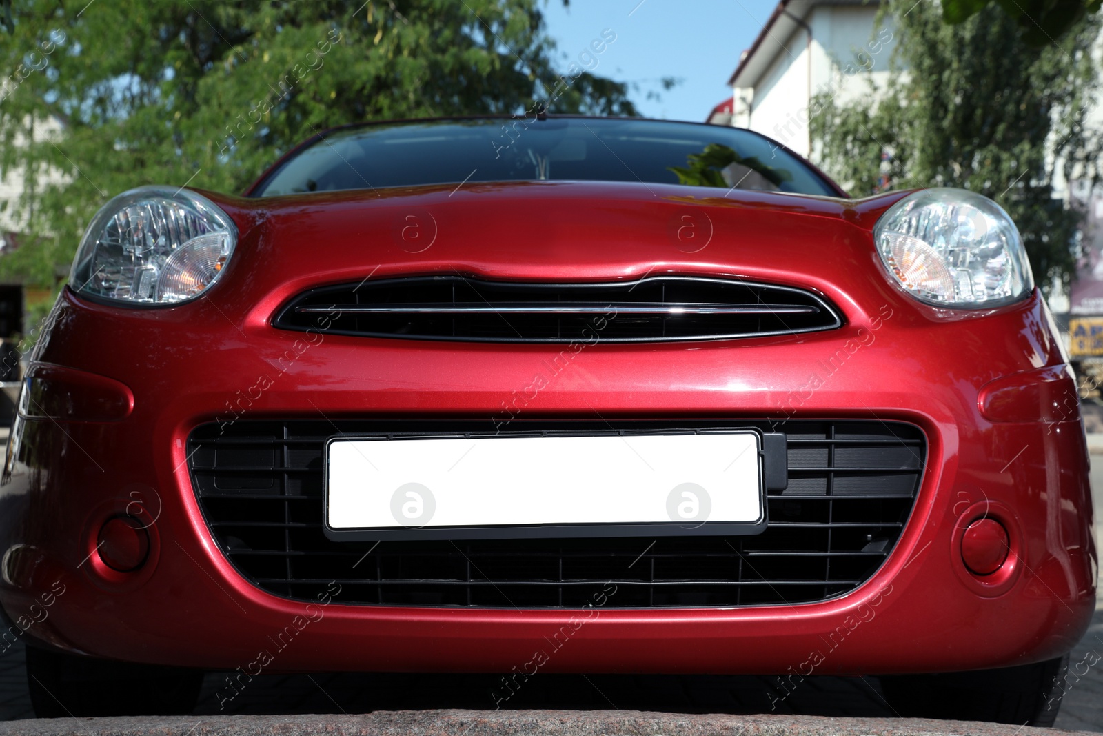 Photo of Red car with vehicle registration plate outdoors