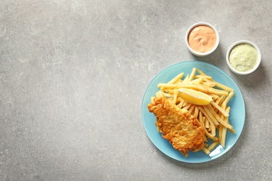 Photo of Plate with British Traditional Fish and potato chips on grey background, flat lay. Space for text