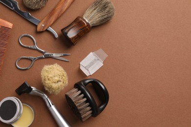 Photo of Moustache and beard styling tools on brown background, flat lay. Space for text