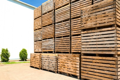 Photo of Pile of empty wooden crates at warehouse backyard on sunny day. Space for text