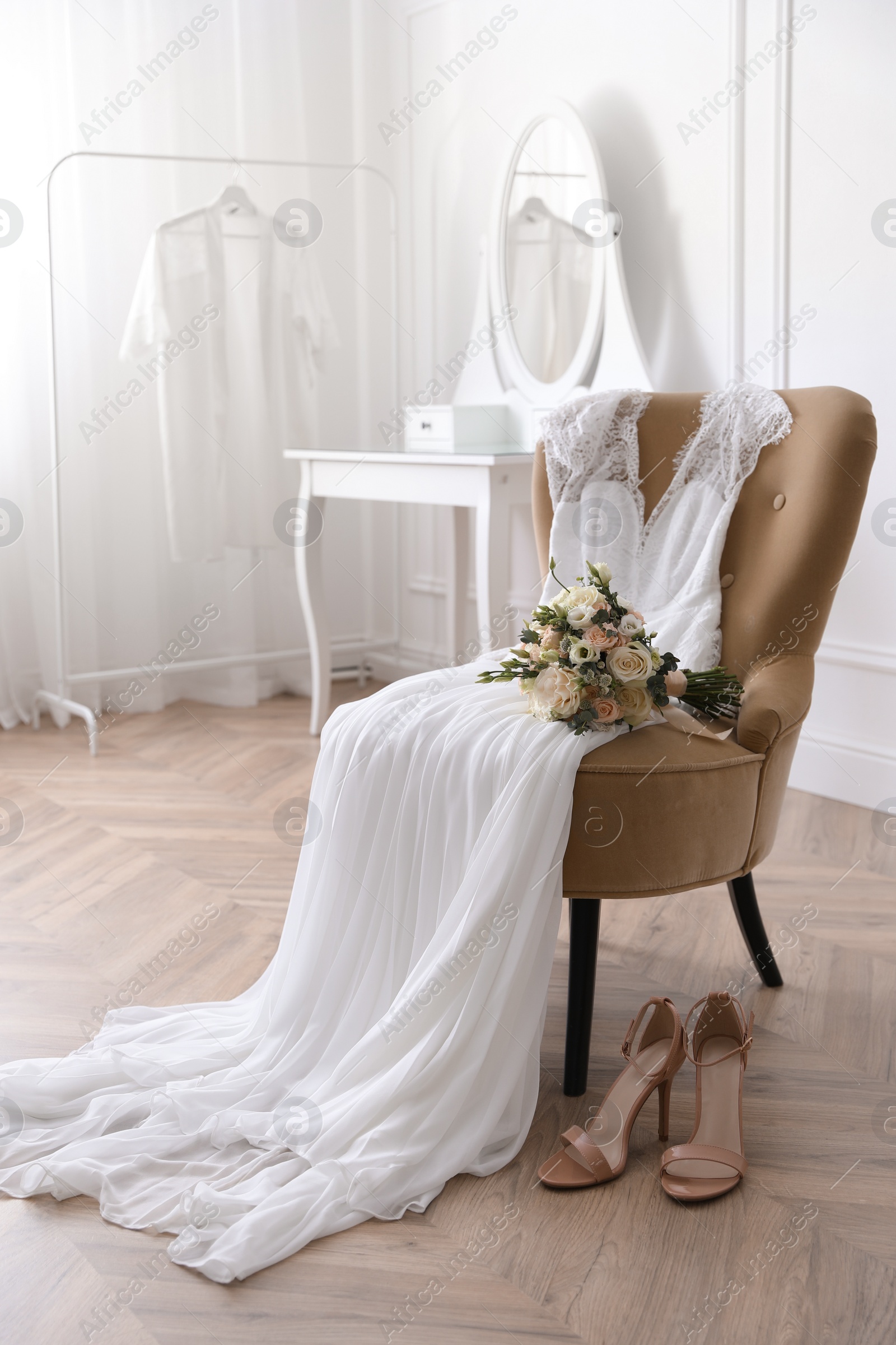 Photo of Elegant wedding dress, shoes and bouquet in room