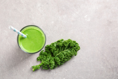 Photo of Tasty kale smoothie on light grey marble table, flat lay