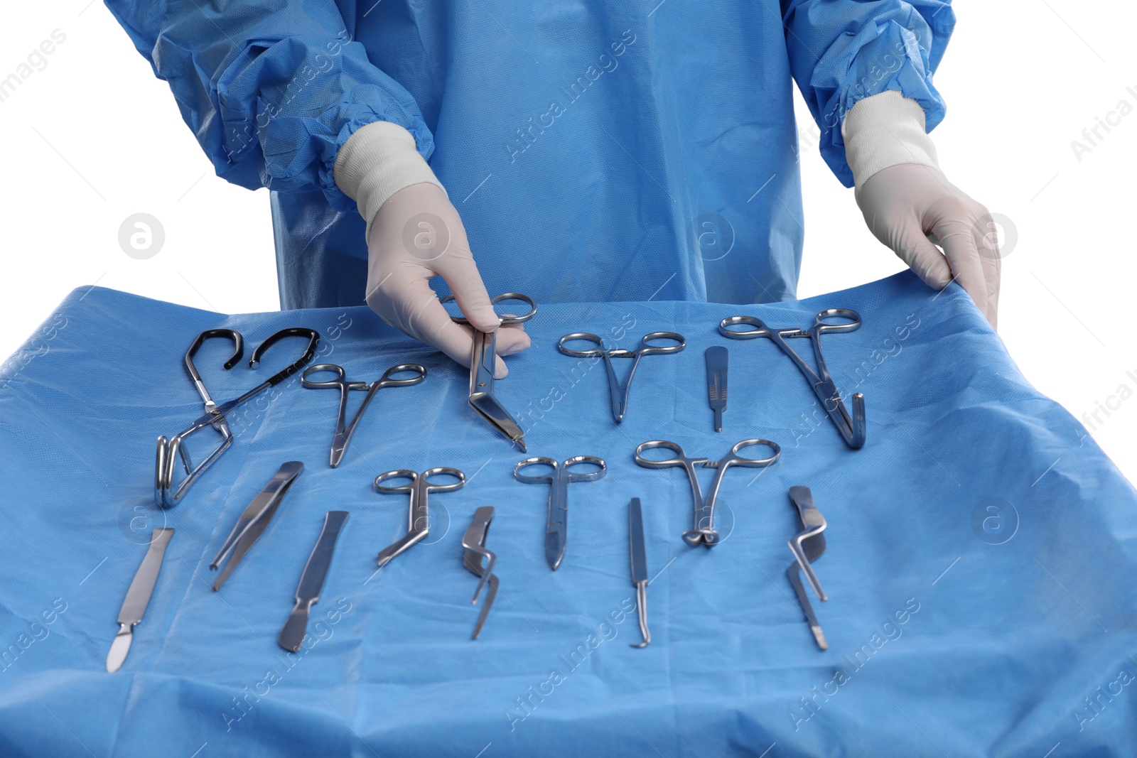 Photo of Doctor holding Pott's scissors near table with different surgical instruments on light background, closeup