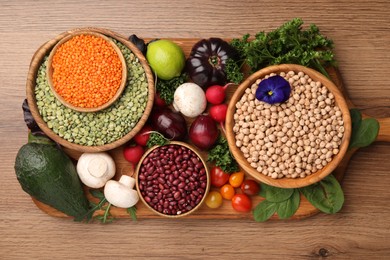 Different vegetables on wooden table, flat lay. Vegan diet