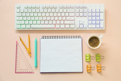 Photo of Modern keyboard with RGB lighting and stationery on pink background, flat lay