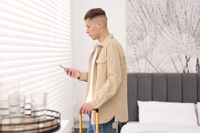 Guest with smartphone in stylish hotel room