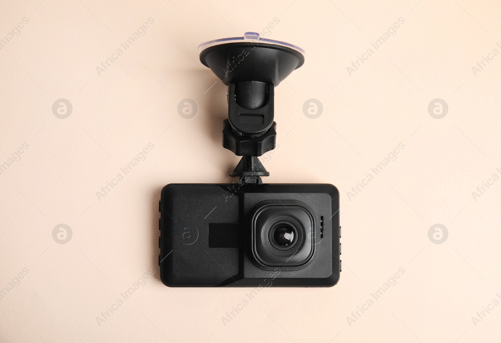 Photo of Modern car dashboard camera with suction mount on light pink background, top view