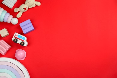 Photo of Different children's toys on red background, flat lay. Space for text